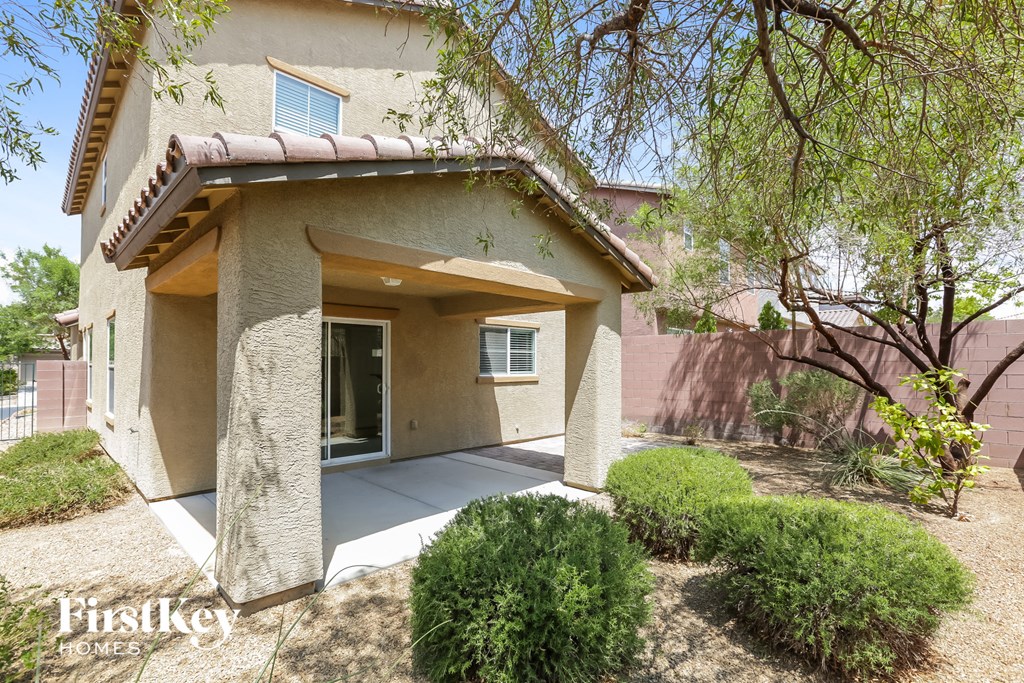 a beige house with a front porch and a tree