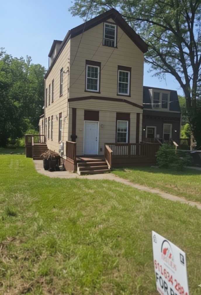 A two story house with a sign in front of it.
