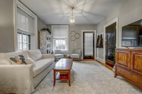 A living room with a white couch and a wooden coffee table.