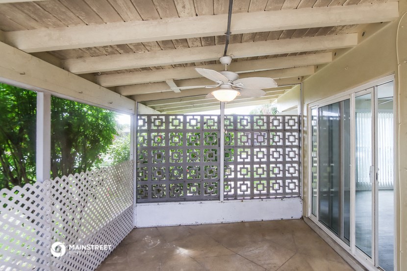 a patio with a ceiling fan and glass doors
