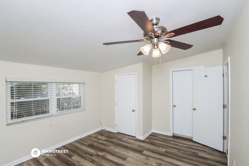 the living room of our studio apartment atrium with a ceiling fan and a window