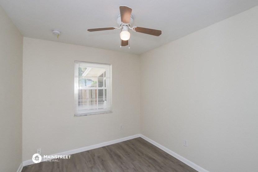 a bedroom with a ceiling fan and a window