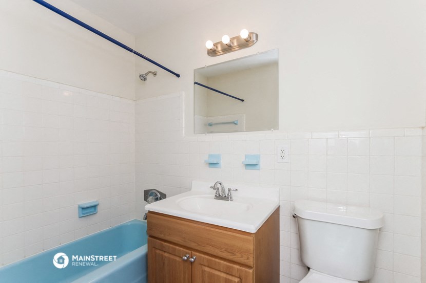 a bathroom with a toilet sink and mirror and a tub