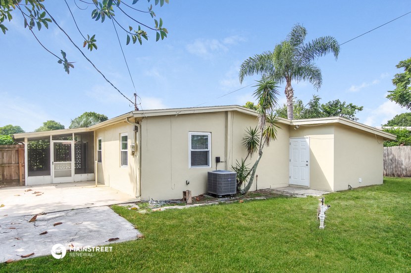 a beige house with a palm tree in the yard