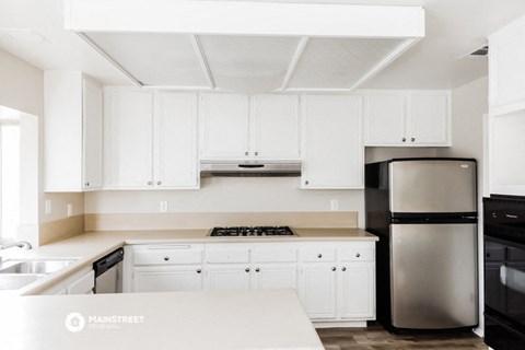 a white kitchen with black appliances and white cabinets