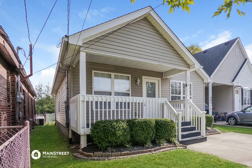 the front of a white house with a porch and stairs