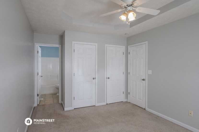 a bedroom with two closets and a ceiling fan