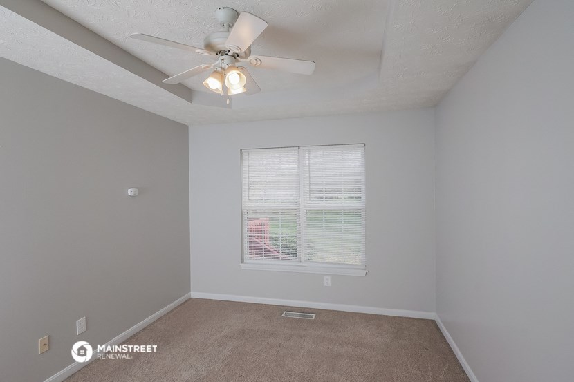 a bedroom with a ceiling fan and a window