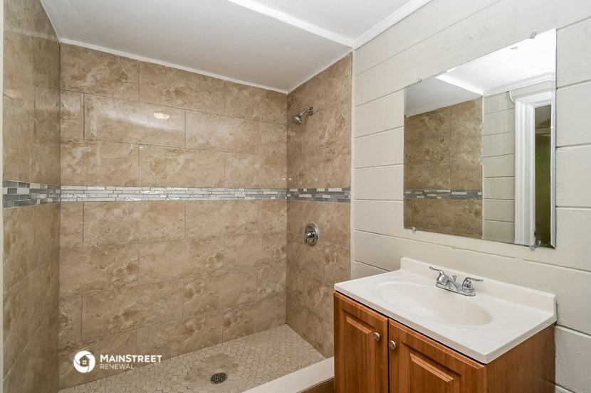 a bathroom with a sink and a shower and a mirror