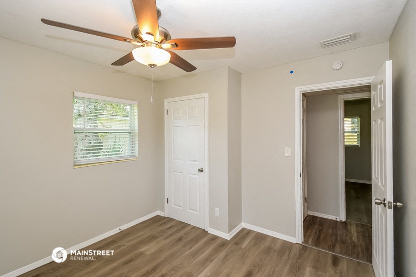 the living room of our two bedroom apartment atrium with ceiling fan and door to