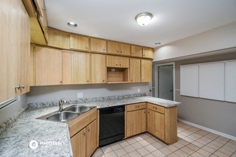 a kitchen with wooden cabinets and granite counter tops and a sink