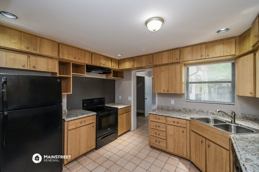 a kitchen with black appliances and wooden cabinets