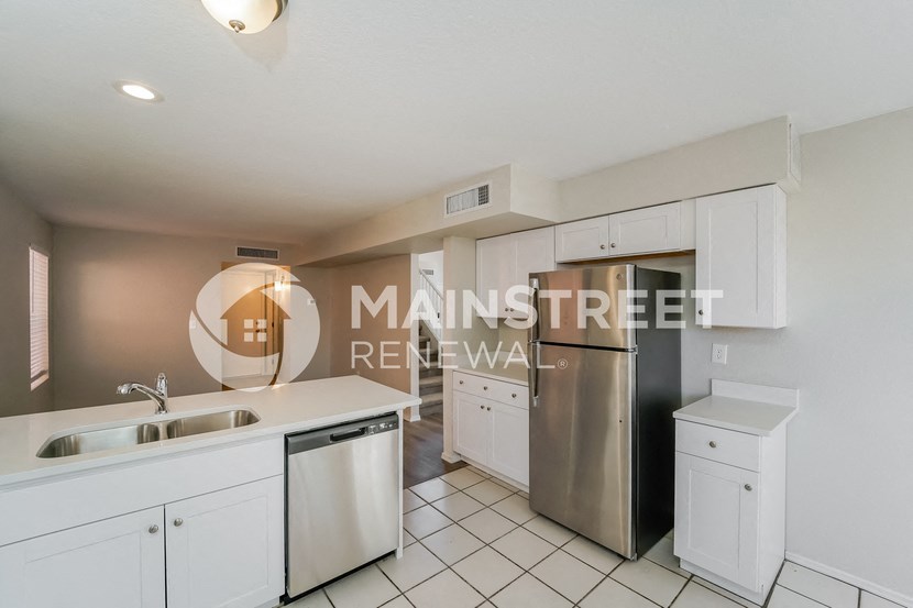 a renovated kitchen with white cabinets and stainless steel appliances