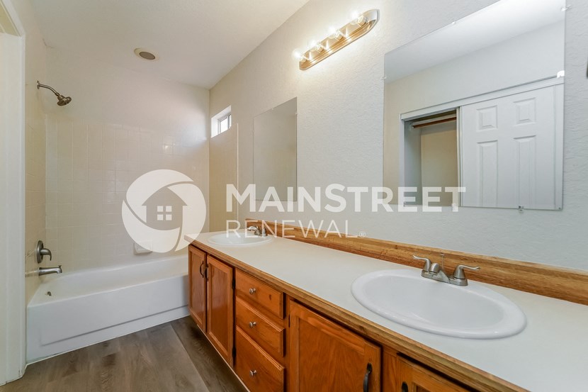 a bathroom with a sink and a tub and a mirror