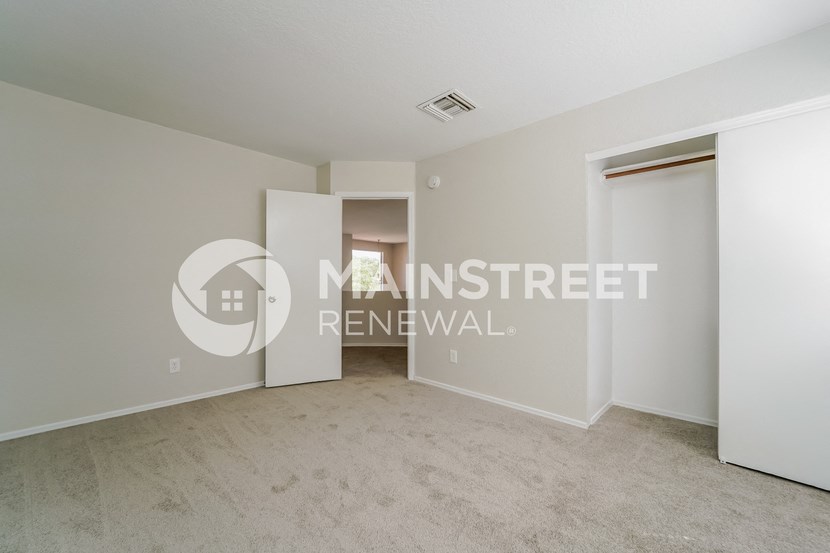 a bedroom apartment with a closet and a door