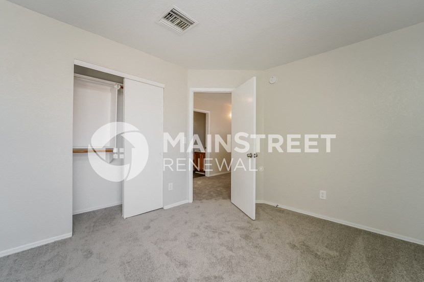 a bedroom with a closet and a door to a bathroom