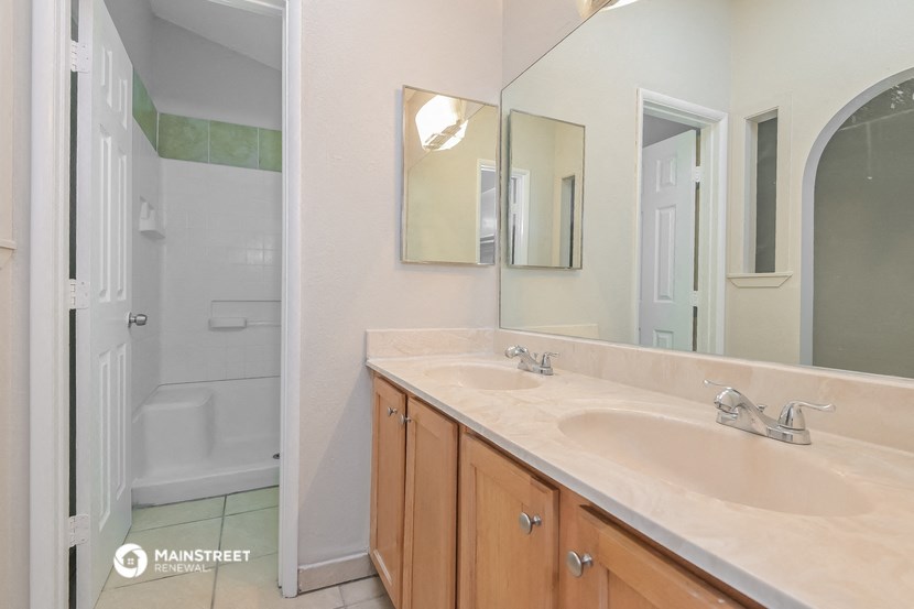 a bathroom with two sinks and a shower and a mirror