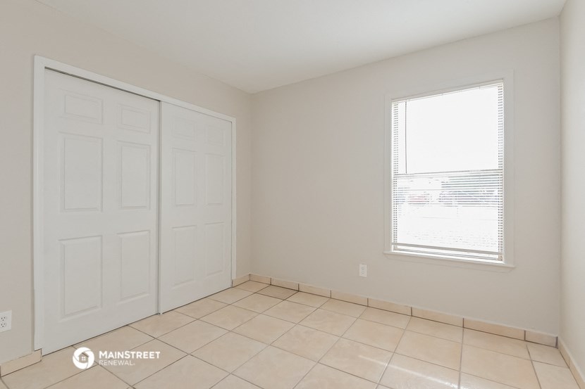 the living room of a home with a tiled floor and a large white door