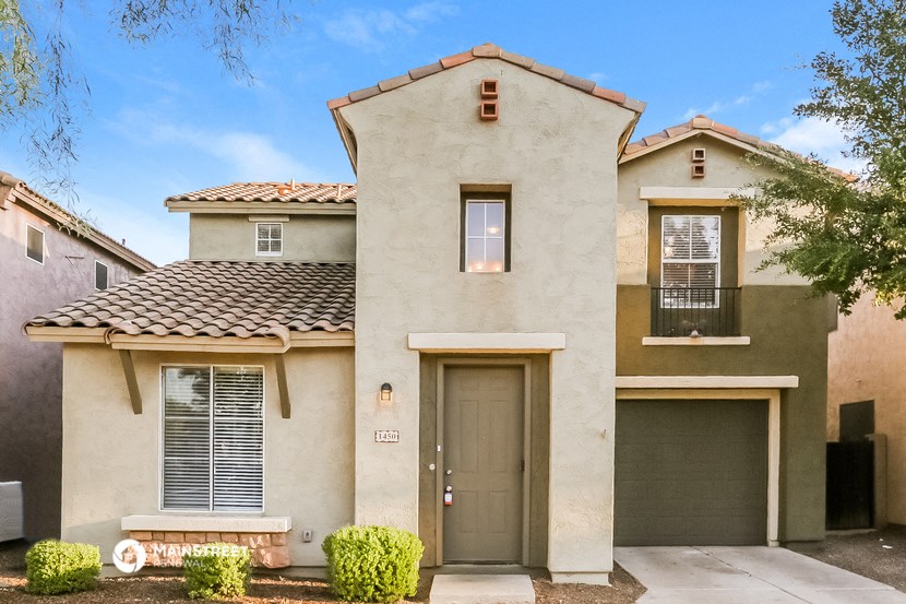 a beige house with two garage doors