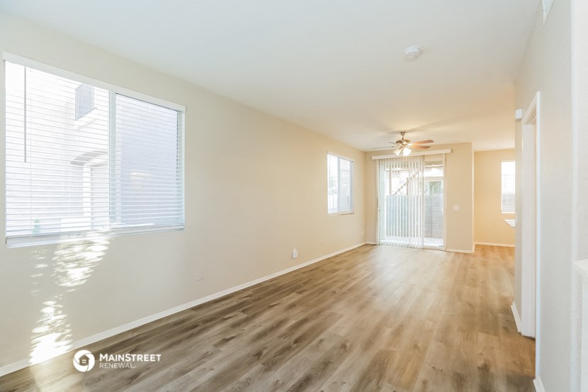 an empty living room with wood flooring and a large window