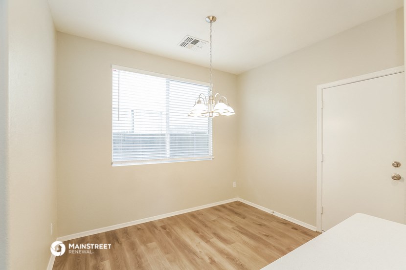 a dining room with a large window and a white table