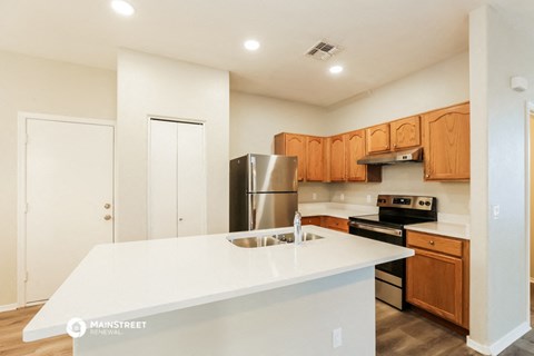 a kitchen with a white counter top and a stainless steel refrigerator