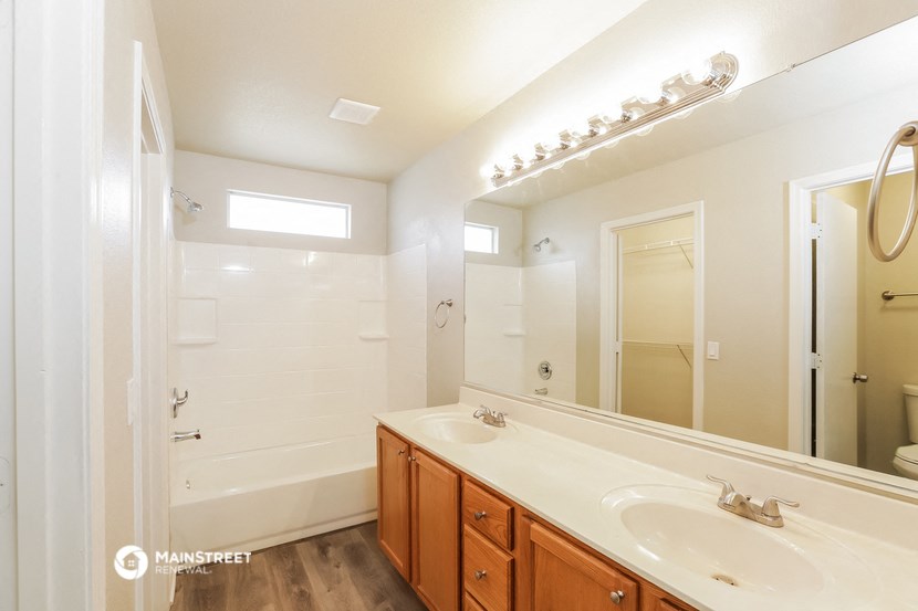 a bathroom with two sinks and a shower and a mirror