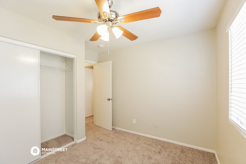 a bedroom with a ceiling fan and a closet