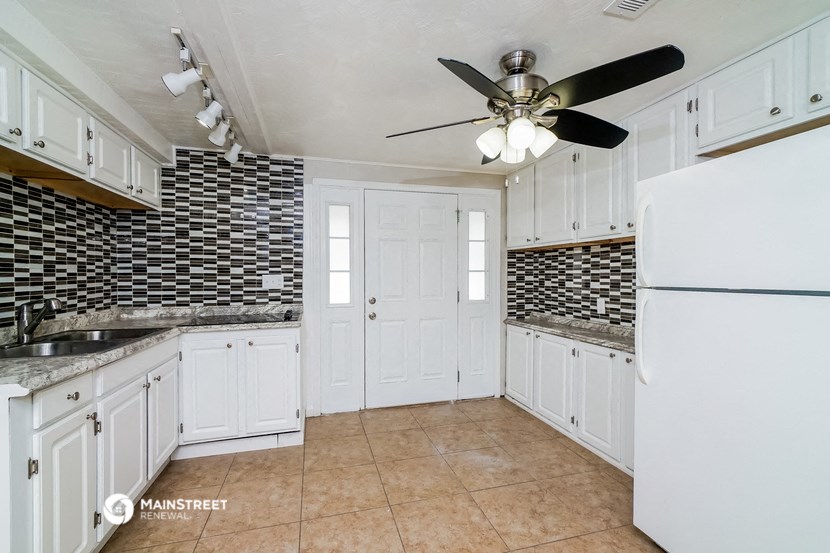 a kitchen with white cabinets and a white refrigerator