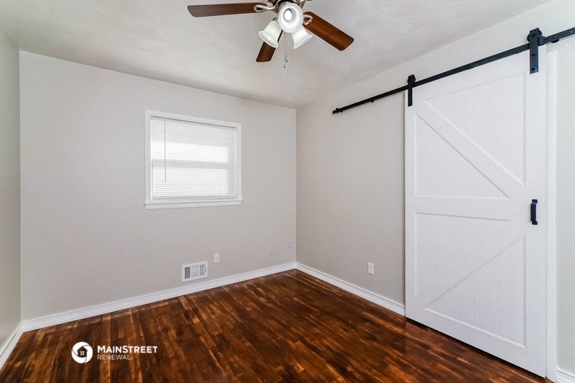the bedroom has a large white closet and a ceiling fan