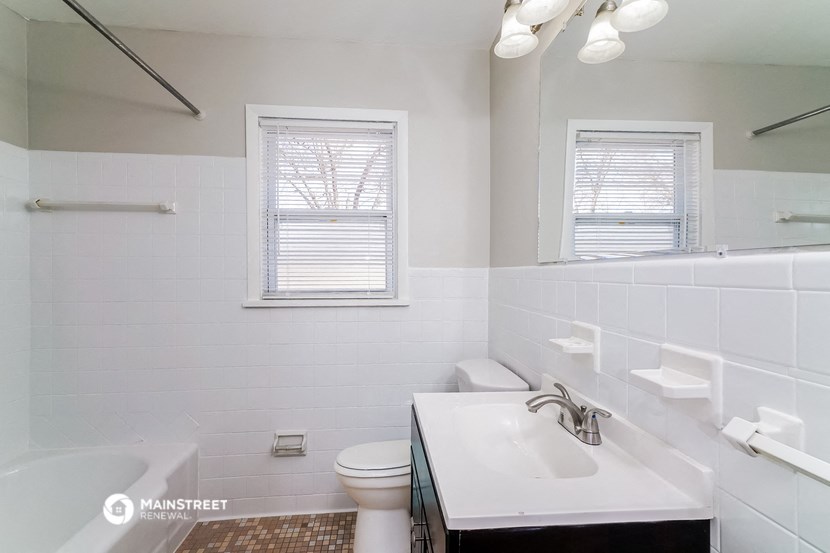 a bathroom with a sink toilet and bath tub and a mirror