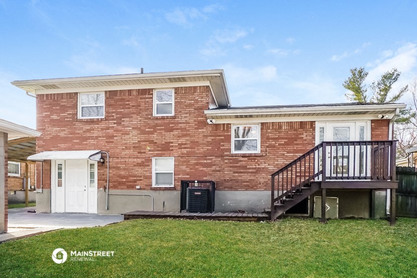 a brick house with a deck and a backdoor