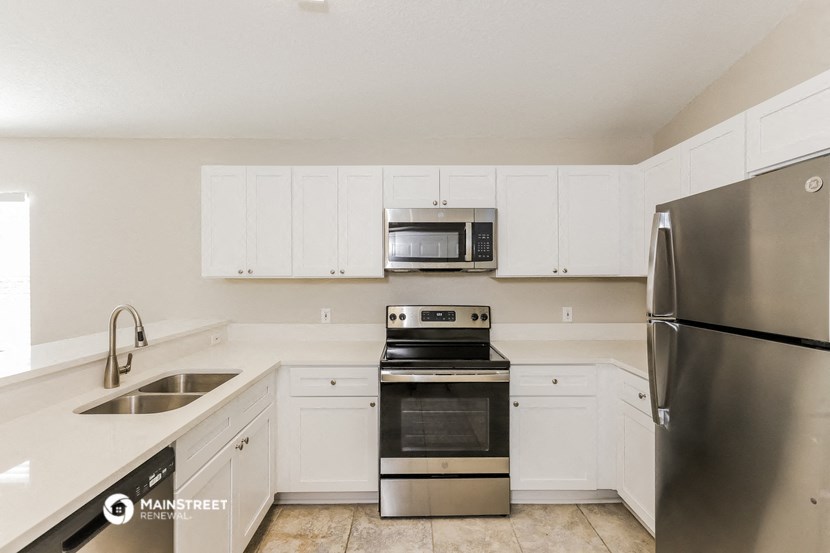 a kitchen with stainless steel appliances and white cabinets