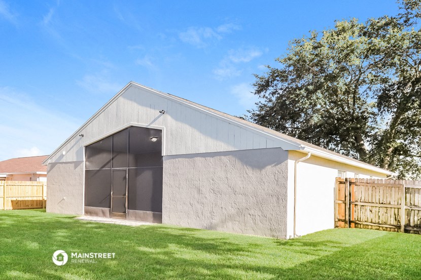 a garage with a large window on the side of it in a backyard
