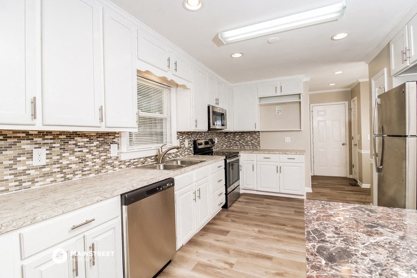 a kitchen with white cabinets and stainless steel appliances