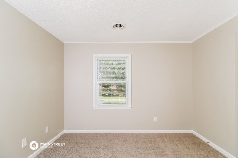 a empty room with a window and carpet
