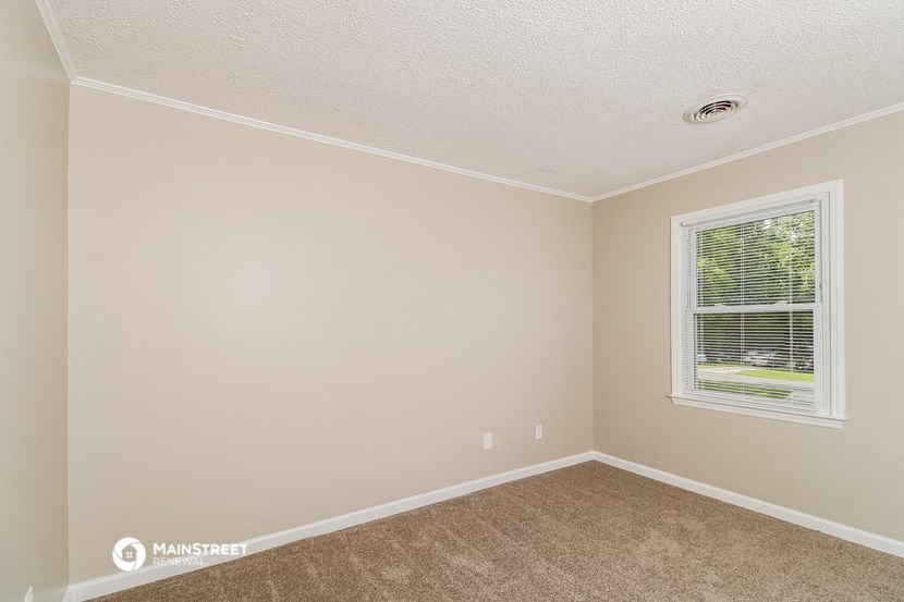 an empty room with carpet and a window