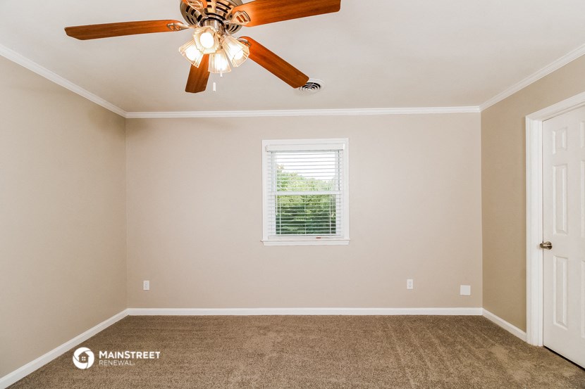 the master bedroom has a ceiling fan and a carpeted floor