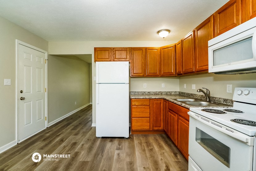 a kitchen with white appliances and wooden cabinets