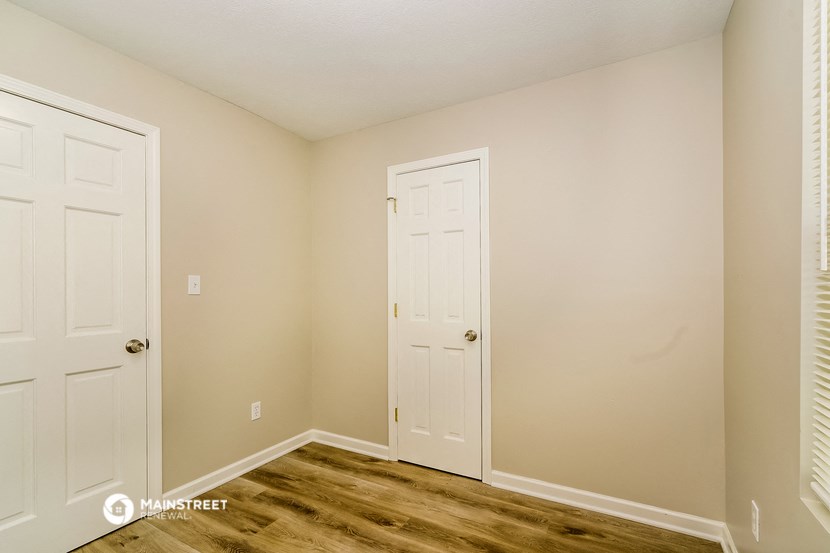 a bedroom with two doors and a door to a closet