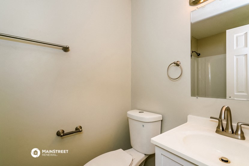 a bathroom with a toilet and a sink and a mirror