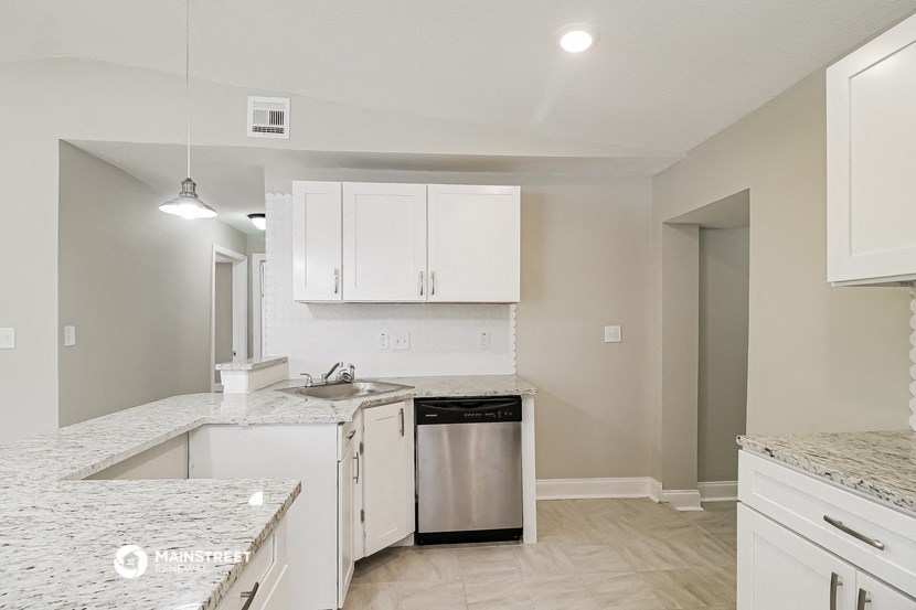 a kitchen with white cabinets and a sink and a dishwasher