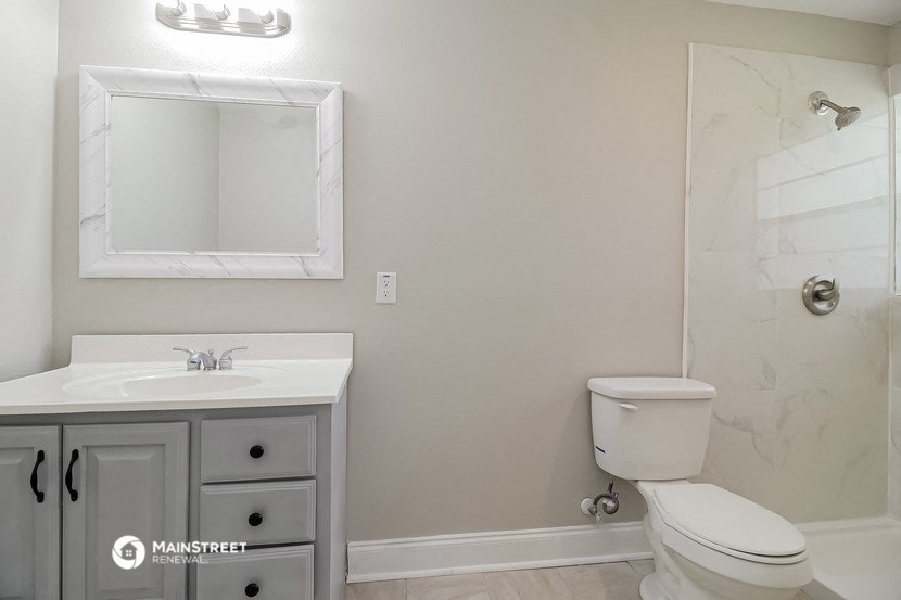 a bathroom with a sink toilet and a mirror