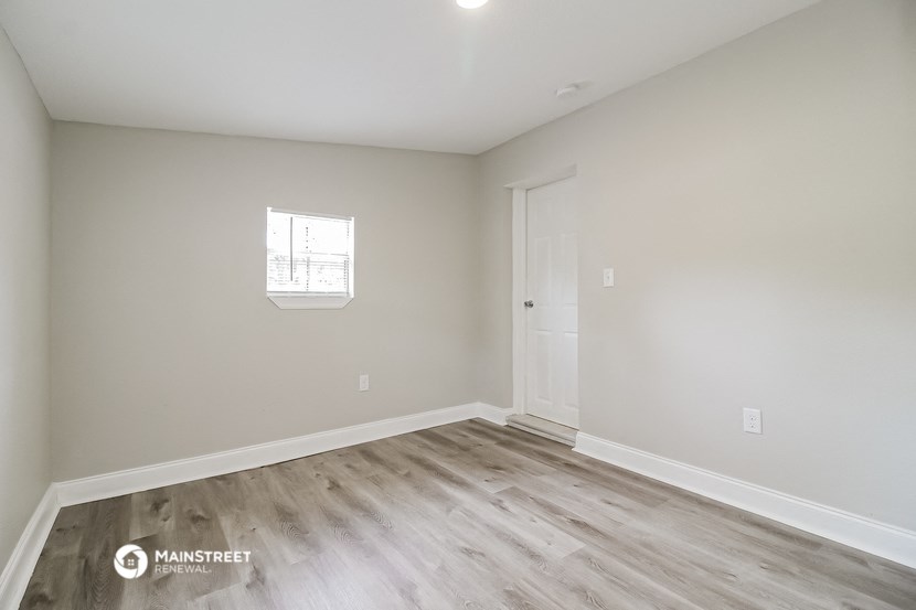 an empty room with a door and a window