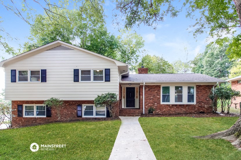 a white house with blue shutters and a lawn