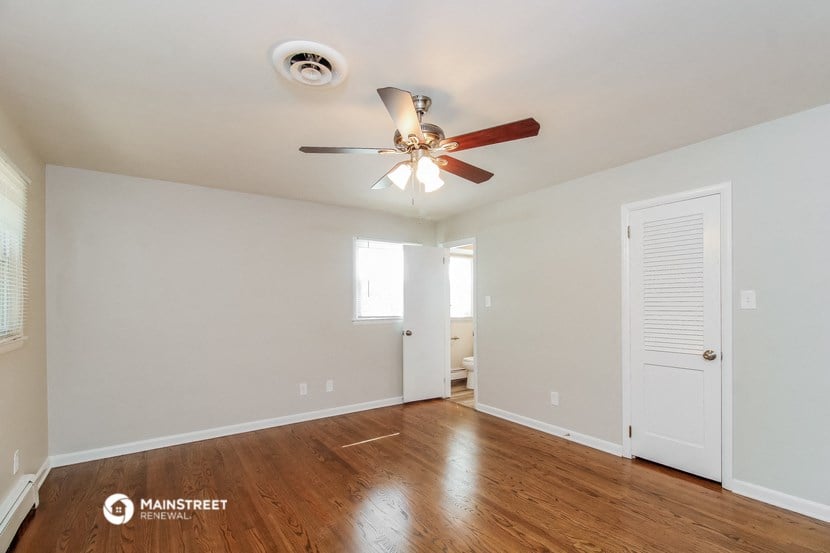 a living room with wood floors and a ceiling fan