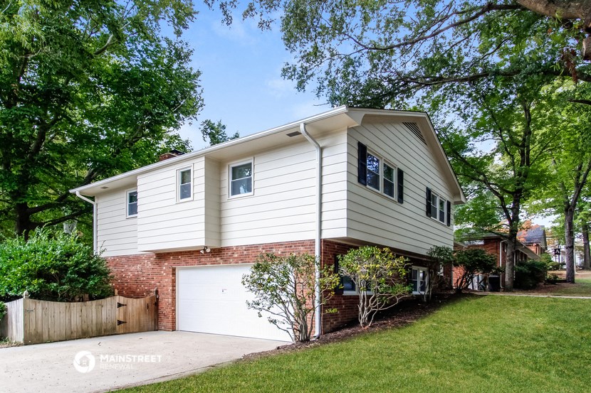 a white and brick house with a white garage door