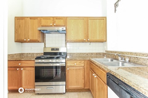 a kitchen with wooden cabinets and a stove and a sink