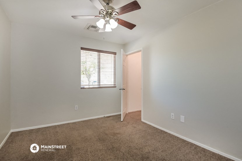 a bedroom with a ceiling fan and a window