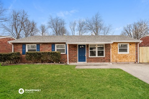 a brick house with a blue door and a lawn